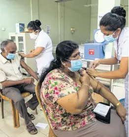  ?? AP ?? A Sri Lankan couple receive the vaccine for COVID-19 at a municipal health centre in Colombo, Sri Lanka, yesterday.