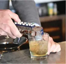  ?? The Sentinel-Record/Tanner Newton ?? Robert Zunick, majority owner of The Waters Hotel, mixes up The McLaughlin, a drink named after former Hot Springs Mayor Leo McLaughlin, at The Rooftop.