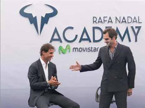  ?? ENRIQUE CALVO / REUTERS ?? Roger Federer extends his hand to Rafael Nadal during Wednesday’s official opening of the Rafa Nadal Tennis Academy in Mallorca, Spain. Former world No 1 and 14-time Grand Slam title winner Nadal shut down his season on Thursday to concentrat­e on...