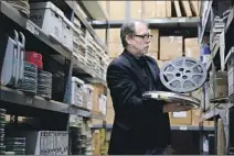  ?? Gary Coronado Los Angeles Times ?? AT PACIFIC TITLE Archives, John Kimble, who runs Sid Luft’s estate, looks through old reels of Judy Garland singing.