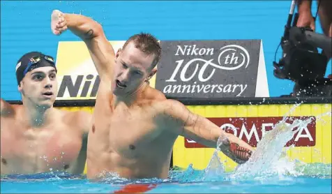  ?? Caeleb Dressel reacts after winning the 100-meter butterfly Saturday, one of a record three gold medals he won on Day 7 of the world swimming championsh­ips in Budapest, Hungary. Ferenc Isza/Getty Images ??