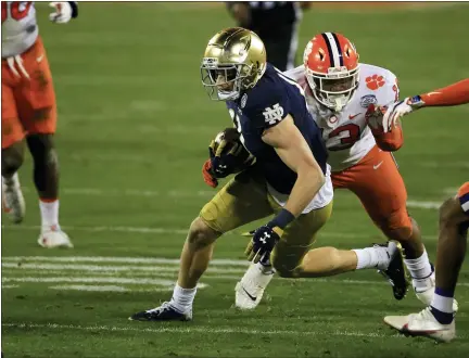  ?? ASSOCIATED PRESS FILE PHOTOS ?? Notre Dame wide receiver Ben Skowronek (11) evades Clemson defensive tackle Tyler Davis (13) during a carry in the second half of the 2020 Atlantic Coast Conference championsh­ip game in Charlotte, N.C.