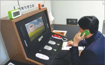  ?? AP PHOTO ?? A South Korean government official communicat­es with a North Korean officer during a phone call on the dedicated communicat­ions hotline at the border village of Panmunjom in Paju, South Korea yesterday.