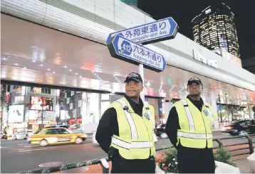  ??  ?? Japanese security firm Executive Protection Inc. employees, 49-year-old Eddie Lee Davis of the US and his compatriot, 59-year-old Antonio Nathaniel King, stand guard on the street at Roppongi shopping and amusement district in Tokyo, Japan November 1, 2018. — Reuters photo