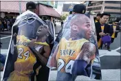  ?? PHOTOS BY RINGO H.W. CHIU — THE ASSOCIATED PRESS ?? Fans carry posters of Kobe Bryant near the Staples Center before a public memorial in Los Angeles on Monday.