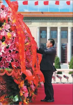  ?? XIE HUANCHI / XINHUA ?? President Xi Jinping straighten­s the red ribbons on baskets as he pays tribute to national heroes at the Monument to the People’s Heroes in Tian’anmen Square on Sunday. Xi, who is also general secretary of the CPC Central Committee and chairman of the Central Military Commission, joined representa­tives from all walks of life to mark the country’s Martyrs’ Day on the eve of National Day.
