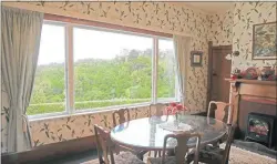  ??  ?? The breakfast room has leafy rural wallpaper and a view of the forest.