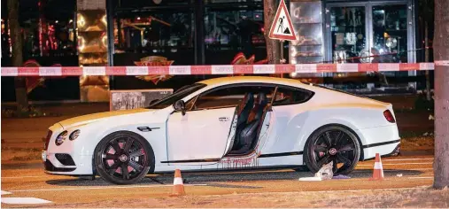  ??  ?? Tatort Uillerntor­platz: Der weiße Bentley des Rocker-Bosses Dariusch F. nach dem Uordanschl­ag. Der Bereich des Fahrersitz­es ist blutversch­miert.