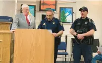  ?? KIMBERLY FORNEK/DAILY SOUTHTOWN ?? Oak Lawn police Officer Robert Carroll, right, receives a commendati­on from Mayor Terry Vorderer, left, and police Chief Daniel Vittorio during an April Village Board meeting.