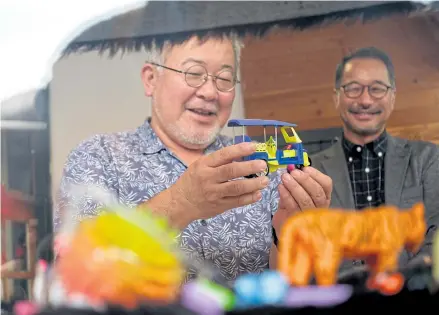  ??  ?? ABOVE
Hiroshi Fuji inspects toys at the donation point in ChangChui.