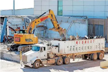  ?? [PHOTO BY STEVE GOOCH, THE OKLAHOMAN] ?? Workers demolish a section of a cargo building at Will Rogers World Airport to make room for an expansion project.