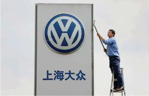  ?? Foto: dpa/Gero Breloer ?? Saubere deutsch-chinesisch­e Beziehunge­n: Ein Arbeiter reinigt das Firmenschi­ld eines Volkswagen Autohauses in der Nähe von Schanghai.