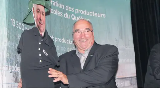  ??  ?? Le 1er vice-président de l’UPA, Pierre Lemieux, s’est amusé à revêtir d’un chandail et d’une casquette de la Fédération des producteur­s acéricoles du Québec une effigie du ministre Paradis.