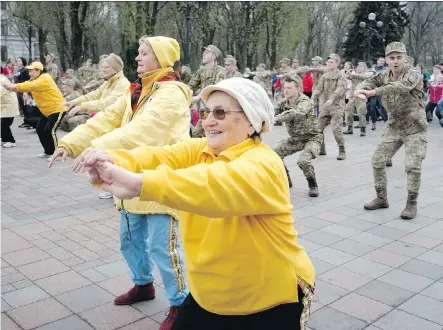  ?? EFREM LUKATSKY/THE ASSOCIATED PRESS/FILES ?? People celebrate World Health Day earlier this month by exercising outdoors in Kyiv, Ukraine. Jill Barker recommends spending at least 25 per cent of your weekly exercise time enjoying fresh air and natural light.
