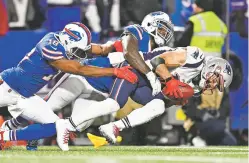  ?? ADRIAN KRAUS/ASSOCIATED PRESS ?? The Patriots’ Julian Edelman, right, collects a punted ball as the Bills’ Andre Holmes, left, and Ramon Humber tackle him during Monday’s game in Orchard Park, N.Y.