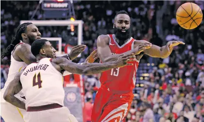  ?? MICHAEL WYKE/THE ASSOCIATED PRESS ?? Rockets guard James Harden passes under pressure from Cavaliers forward Jae Crowder, left, and guard Iman Shumpert on Thursday in Houston. Harden recorded a 35-point triple-double to lead the Rockets to a 117-113 win.