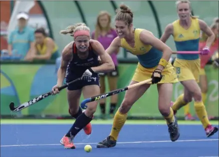  ?? HUSSEIN MALLA — THE ASSOCIATED PRESS ?? United States’ Kathleen Sharkey, left, fights for the ball against Australia’s Emily Hurtz, center, during an Olympic women’s field hockey game in Rio de Janeiro, Brazil, Monday.
