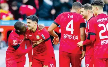  ?? Associated Press ?? ↑
Bayer Leverkusen’s players celebrate after their victory over Augsburg in their German League match on Sunday.