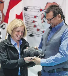  ?? JASON FRANSON / THE CANADIAN PRESS ?? Alberta Premier Rachel Notley presents Chief Billy-joe Laboucan with a buffalo statue on Tuesday after signing a historic land deal with the Lubicon Lake First Nation.
