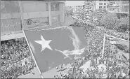  ?? AFP ?? The NLD party’s flag is seen flying at a protest site in Yangon.