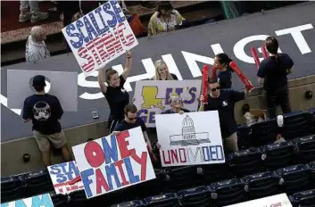  ?? Win McNamee / Getty Images ?? Members of the crowd hold signs supporting wounded Louisiana Rep. Steve Scalise before the start of the Congressio­nal Baseball Game at Nationals Park on Thursday. Scalise and 4 others were wounded during a shooting during practice.