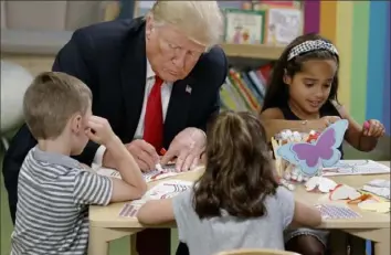  ?? Evan Vucci/Associated Press ?? Mr. Trump colors during a visit Friday with a group of children at the Nationwide Children's Hospital in Columbus.