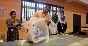  ?? AP/SINAN HUSSAIN ?? An election official empties a ballot box Saturday so the votes can be counted in presidenti­al elections in Male, Maldives.