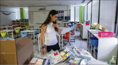  ?? VALERIE PLESCH/WASHINGTON POST ?? Fourth grade teacher Desiree Delgado prepares the classroom for her Spanish immersion students at Bailey’s Upper Elementary School in Virginia, which occupies a five-story brick complex near a busy highway.