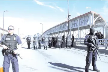  ?? — AFP photos ?? US Customs and Border Patrol agents and riot policemen take part in a border security drill at the US-Mexico internatio­nal bridge, as seen from Ciudad Juarez, Mexico.