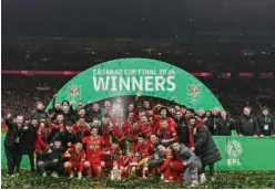  ?? Agence France-presse ?? ↑ Liverpool players pose with the trophy after the winning the English League Cup final against Chelsea at Wembley stadium in London on Sunday.