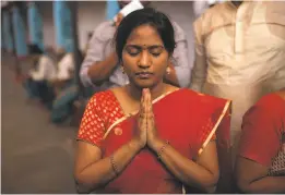  ?? Bernat Parera / Special to The Chronicle 2016 ?? A woman prays while walking laps at Chilkur Balaji Temple outside of Hyderabad. The temple’s deity, Lord Balaji, is believed to be particular­ly powerful in influencin­g the granting of visas. It is said that Balaji will answer prayers if they are offered while walking 108 laps around the site.