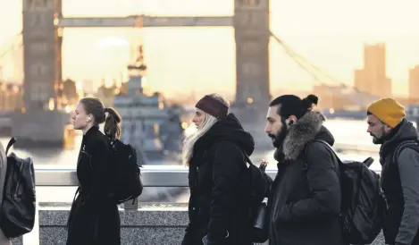  ?? ?? Commuters cross London Bridge on a cold morning in London, Britain, Jan. 16, 2024.