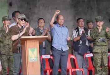  ??  ?? Duterte applauds as he made the announceme­nt on Marawi while defence secretary Delfin Lorenzana raises a clenched fist during a ceremony inside the battle area yesterday.