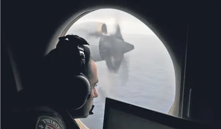  ?? Picture: AP. ?? Flight officer Rayan Gharazeddi­ne on board a Royal Australian Air Force AP-3C Orion, searches for the missing Malaysia Airlines Flight MH370 in the southern Indian Ocean.