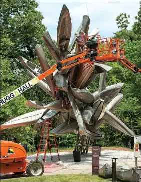  ?? NWA Democrat-Gazette/BEN GOFF • @NWABENGOFF ?? A crew installs the sculpture by Nancy Rubins on June 7 on the North Forest Trail at Crystal Bridges Museum of American Art in Bentonvill­e. The sculpture is fabricated from aluminum canoes and johnboats.