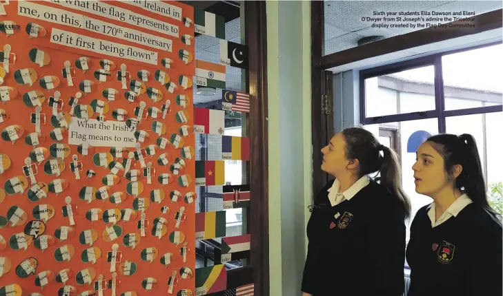  ??  ?? Sixth year students Ella Dawson and Eleni O’Dwyer from St Joseph’s admire the Tricolour display created by the Flag Day Committee