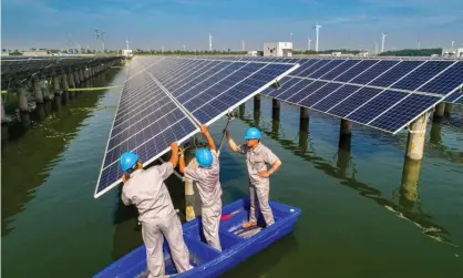  ??  ?? Workers check panels at a solar power station in Hai’an, in China’s Jiangsu province. Photograph: VCG/Getty
