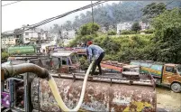  ??  ?? A worker pumps water from the Khahare River to supply a tanker in the Kirtipur area of Kathmandu, Nepal, recently.