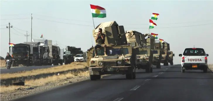  ??  ?? VEHICLES OF the Kurdish Peshmerga driving towards clashes with the Iraqi army.