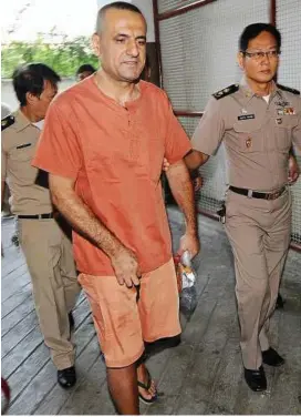  ??  ?? Day in court: Hussein being escorted by prison officers as he appears at the criminal court in Bangkok, Thailand. — AFP