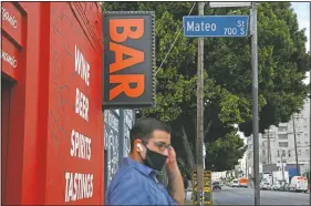  ?? (AP/Jae C. Hong) ?? A man waits Monday for a bus near a bar closed due to the coronaviru­s pandemic in Los Angeles. California Gov. Gavin Newsom on Sunday ordered bars in seven California counties, including Los Angeles, to immediatel­y close and urged bars in eight other counties to do the same.