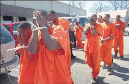  ?? STAN CARROLL/ THE COMMERCIAL APPEAL ?? Defendants head into Benton County courthouse for arraignmen­t on dogfightin­g charges Monday after a weekend raid. Marshall County Sheriff Kenny Dickerson said the 51 suspects are being housed at the Marshall County jail because Benton County did not...