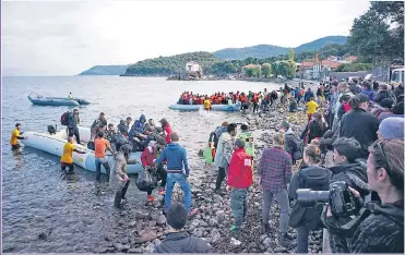  ?? Picture: MILOS BICANSKI/GETTY ?? MIGRANT CRISIS: Boatloads of immigrants coming ashore at Lesbos in Greece