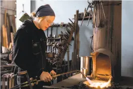  ??  ?? Lovell, using ancient techniques, works on a metal project in her Alameda studio. The blacksmith won an $86,000 commission from the city of Oakland to create gates for the Gardens at Lake Merritt.