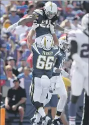  ?? Adrian Kraus Associated Press ?? CHARGERS guard Dan Feeney, hoisting Melvin Gordon, is facing a difficult task against the Rams.