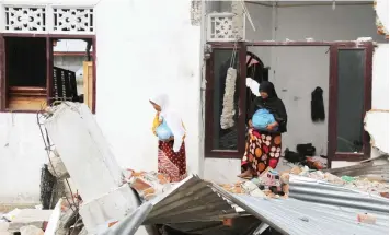  ?? — AFP ?? Villagers search for their belongings from their collapsed house at Kuta Pangwa village, in Pidie Jaya, Aceh province, on Saturday.