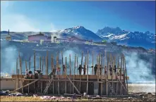  ?? LI LONGDE / FOR CHINA DAILY ?? Tibetans build a new house in a village in Ganzi Tibetan autonomous prefecture, Sichuan province, on Oct 13, 2013. The per capita income in rural areas of Tibet increased by 10.2 percent year- on- year in the first six months of 2020.