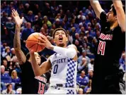  ?? AP PHOTO BY JAMES CRISP ?? Kentucky’s Quade Green shoots between Louisville’s Ray Spalding (13) and Anas Mahmoud (14) during the second half Friday in Lexington, Ky. Kentucky won 90-61.