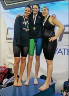  ??  ?? From left, Notre Dame’s Michael McGeary and Episcopal Academy’s Emma Seiberlich and Maddie O’Reilly pose with their medals in the 100 freestyle at Easterns. Seiberlich won, McGeary was third and O’Reilly eighth.