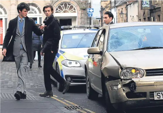  ?? Picture: Mhairi Edwards. ?? The public look on after the VW Golf hit a shop front in St Andrews, injuring Chinese exchange students.